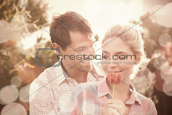 Young couple holding a flower in park