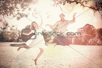 Cute couple jumping in the park together