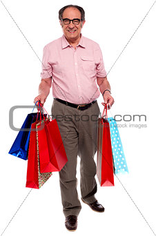 Happy matured man carrying shopping bags