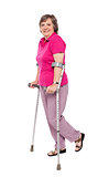 Smiling senior woman walking with crutches