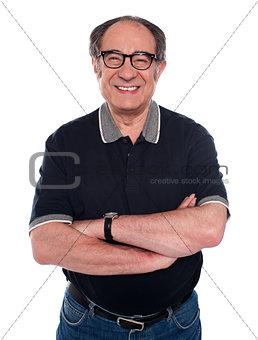 Cheerful old man standing with arms crossed