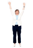 Excited senior woman posing with raised arms