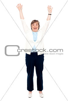 Excited senior woman posing with raised arms