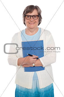 Happy aged woman holding notebook and pen