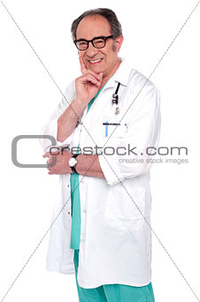 Senior male doctor posing against white