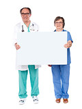 Aged doctors displaying white billboard