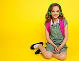 Pretty girl kid listening to music. Seated on floor