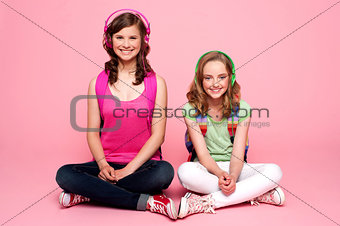 Two school friends sitting on studio floor
