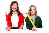 Female students writing with big pencil