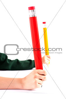 Two girls hands holding big pencil. Closeup