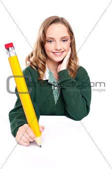 Young girl using an over sized pencil