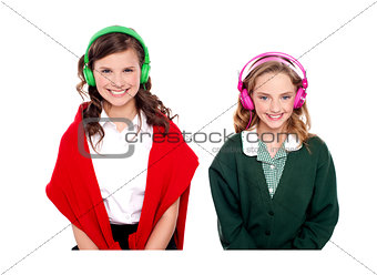 Schoolgirls listening music through headphones