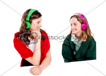 Pretty girls enjoying music. Looking at each other