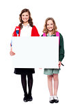 Schoolgirls holding big blank banner ad