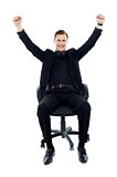 Excited young man sitting on chair