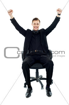 Excited young man sitting on chair