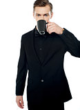 Smart young man drinking coffee in black cup