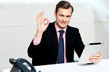 Smiling corporate male showing ok sign