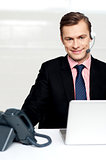 Male executive wearing headsets and smiling