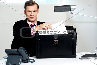 Male executive keeping documents safely
