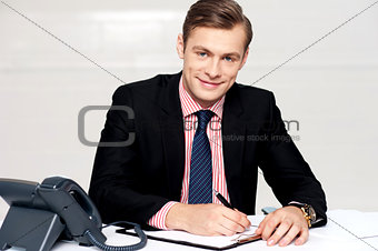 Handsome young man making notes