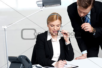 Woman discussing problem with male colleague