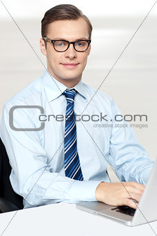 Man sitting on chair using laptop in office