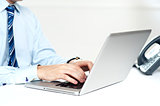 Closeup shot of man working on a laptop