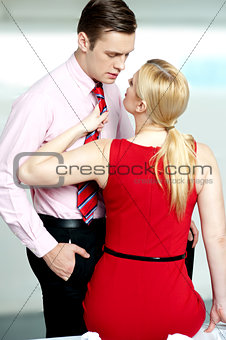 Woman pulling man from his tie. Feeling naughty