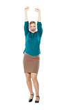 Joyful corporate woman posing with raised arms