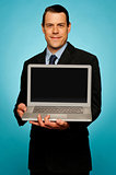 Corporate executive showing laptop to you
