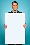 Corporate man holding big white blank billboard