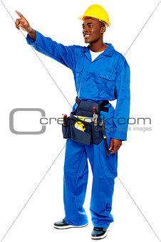Young african male worker pointing at copy space