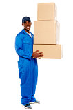 Young delivery boy holding cardboard boxes