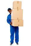 Delivery boy carrying heavy boxes
