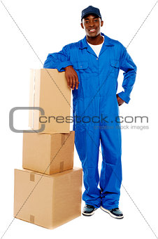 Courier boy standing beside boxes