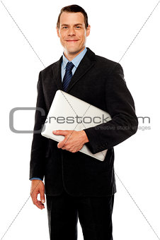 Handsome business executive holding laptop