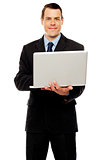 Confident executive using laptop and surfing web