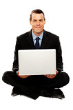 Male executive with laptop sitting on the floor