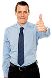 Smiling young man with thumbs up gesture