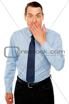 Surprised businessman with hand on mouth