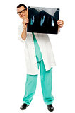 Young surgeon showing x-ray report of patient