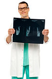 Handsome young surgeon holding x-ray