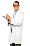 Medical expert posing with report and pen