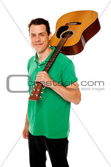Handsome casual man with guitar on shoulders