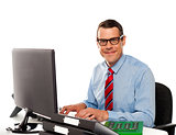 Happy young corporate man using computer