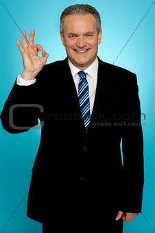 Experienced businessman showing okay sign