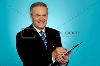 Attractive senior man writing on clipboard
