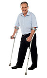 Senior man standing with the help of crutches