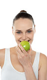 Closeup portrait of beautiful woman eating green apple